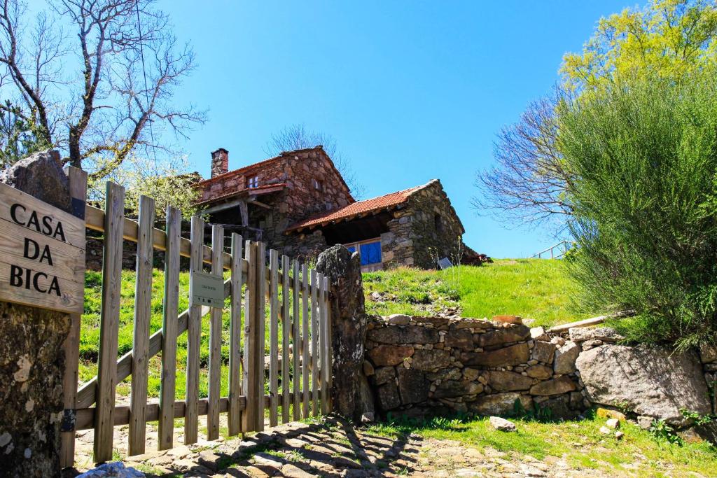 une vieille maison sur une colline avec une clôture en bois dans l'établissement Branda da Aveleira, à Branda da Aveleira