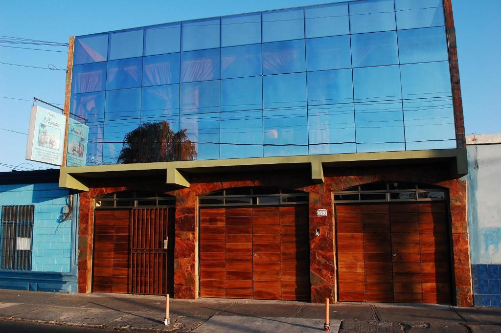 a building with mirrored windows and two garage doors at Hostal Portales in Arica