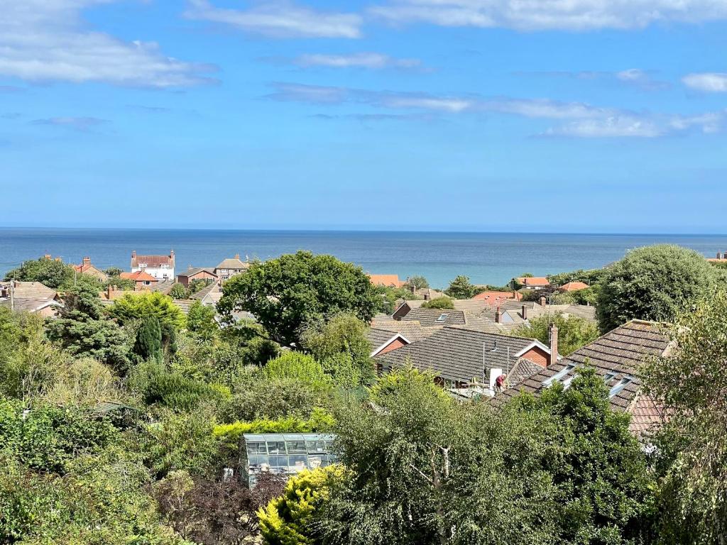 a group of houses on a hill next to the ocean at Highview House Norfolk Coast - seaviews, beach, hot tub in Mundesley