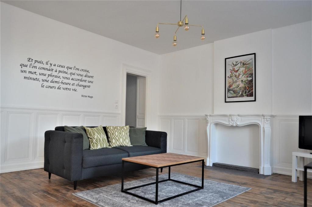 a living room with a couch and a coffee table at Appartement La palette in Villers-Semeuse