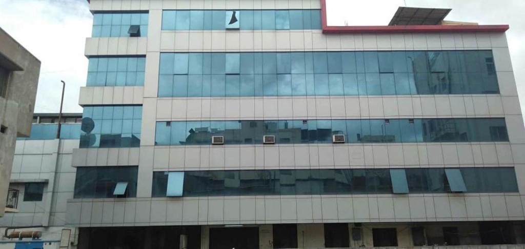 a tall building with a lot of glass windows at iROOMZ Hoysala Residency in Bellary