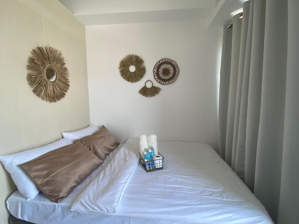 a bedroom with a bed with two mirrors on the wall at 1BR unit in South Residence Las Pinas with Wifi & Netflix in Manila
