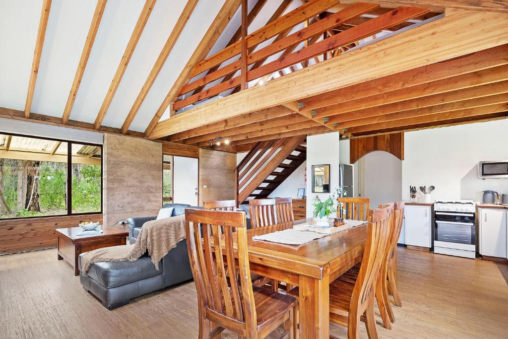 kuchnia i salon z drewnianym stołem i krzesłami w obiekcie Kookaburra Cottage at Woodstone Estate w mieście Dunsborough