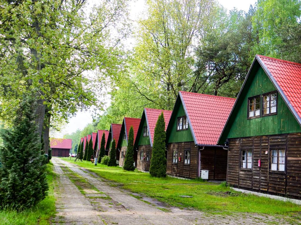eine Reihe von Holzhäusern mit roten Dächern in der Unterkunft Półwysep Natura Tour in Jastarnia