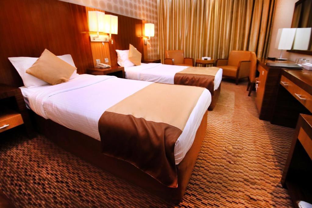 um quarto de hotel com duas camas e uma secretária em Sun And Sands Downtown em Dubai