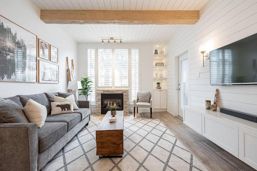 a living room with a couch and a tv at Designer Cozy Ski in and out in Whistler