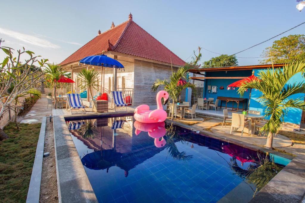 a swimming pool with a pink flamingo in front of a house at Candiva Family House in Nusa Lembongan