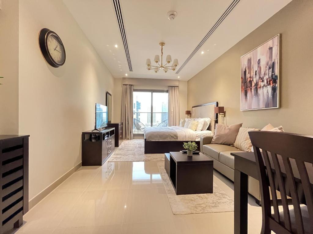 - un salon avec un canapé, un lit et une télévision dans l'établissement Trophy - Downtown Scape Views Suite, à Dubaï
