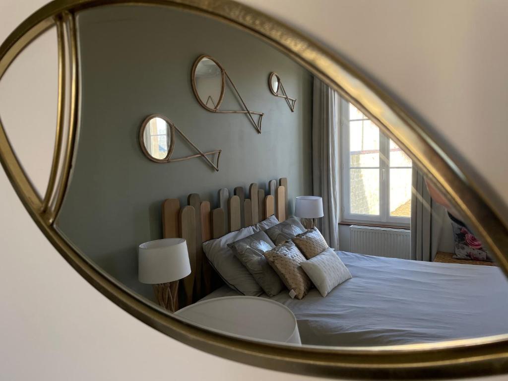 a mirror reflecting a bedroom with a bed with pillows at Aurefees in Ellon