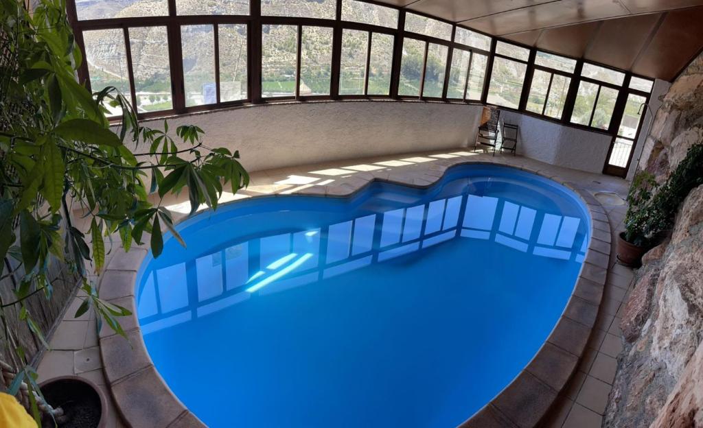 an overhead view of a swimming pool with blue water at Casa cueva con encanto in Terque