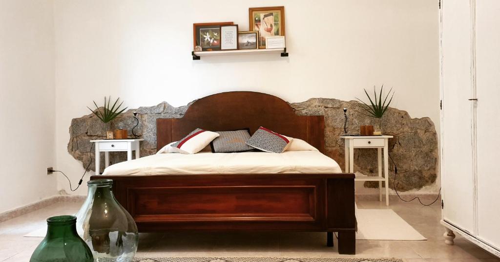 a bedroom with a wooden bed with two tables at Tranquillità e comodità a due passi dal centro in Tortolì