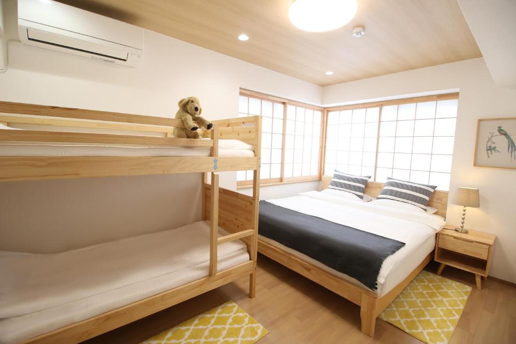 1 dormitorio con 2 literas y un osito de peluche en Uhome Suido Apartment SD, en Tokio