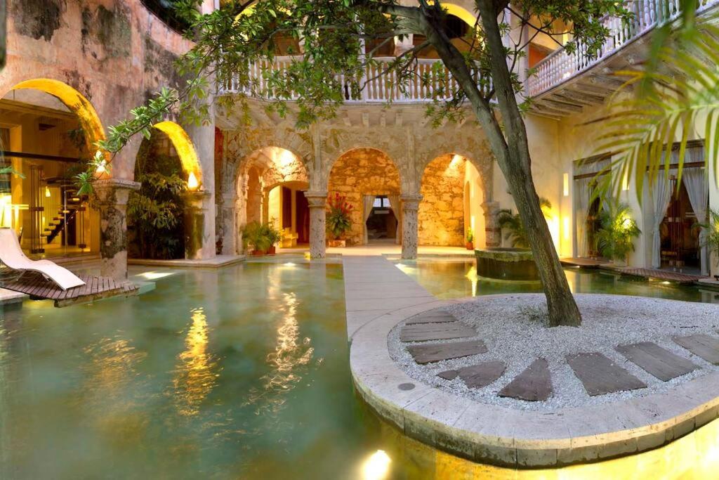 un patio con un árbol en el medio de un edificio en Casa Pombo Luxury 3 largeBR Duplex old city 300m2, en Cartagena de Indias