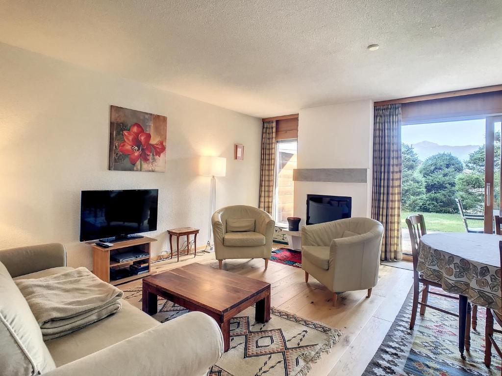 a living room with a couch and chairs and a television at Appartement Andrea in Verbier