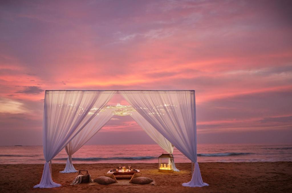 a wedding tent on the beach with a sunset at Cinnamon Bentota Beach - Signature Selection in Bentota