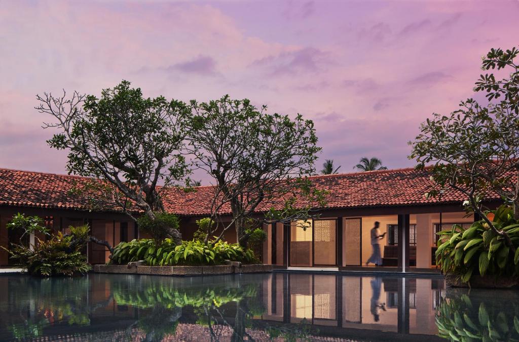 a villa with a pool in front of a house at Cinnamon Bentota Beach - Signature Selection in Bentota