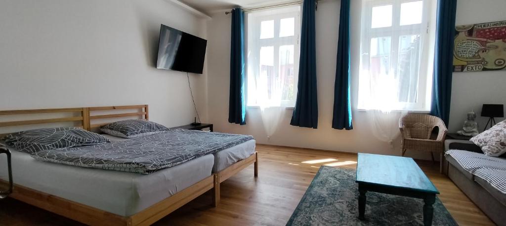 um quarto com uma cama, um sofá e janelas em Apartment Spielberk em Brno