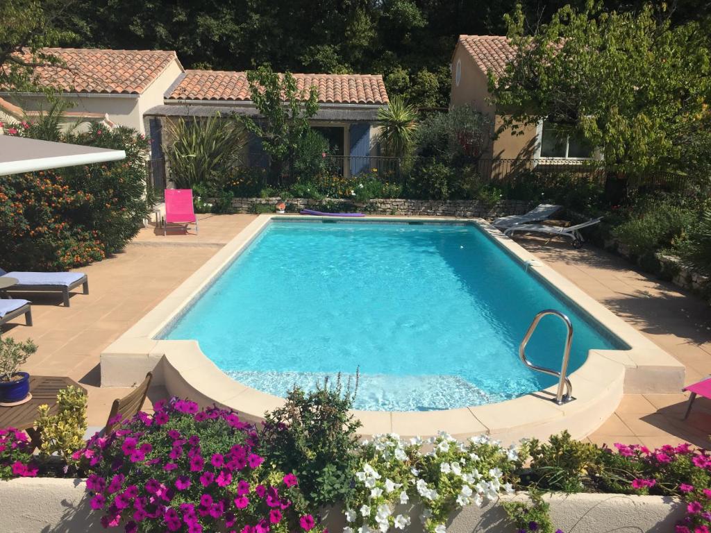 - une piscine dans une cour fleurie dans l'établissement Les Hauts d'Eyragues gîte Aigue Marine Meublé classé 4 étoiles, à Eyragues