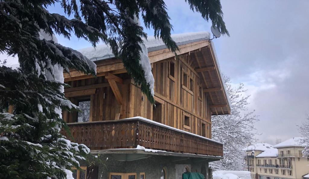 un gran edificio de madera con nieve. en Chalet Chèvrefeuille en Saint-Gervais-les-Bains