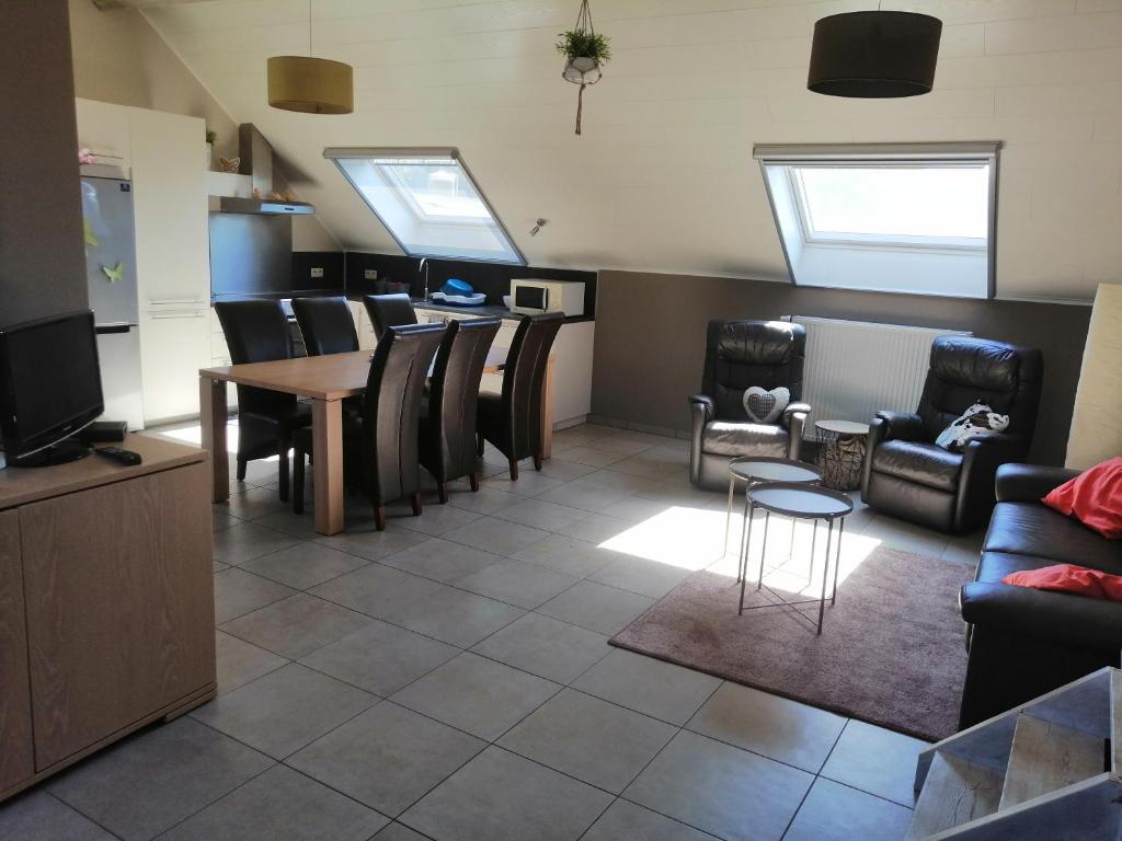 Gîte Ferme d'hurtaux في فرويد-شابيل: غرفة معيشة مع طاولة وكراسي