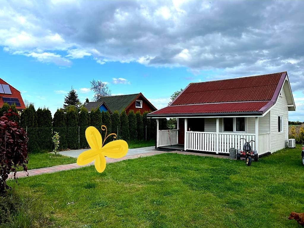 a yellow flower in the grass in front of a house at Domki u Eryka in Międzywodzie