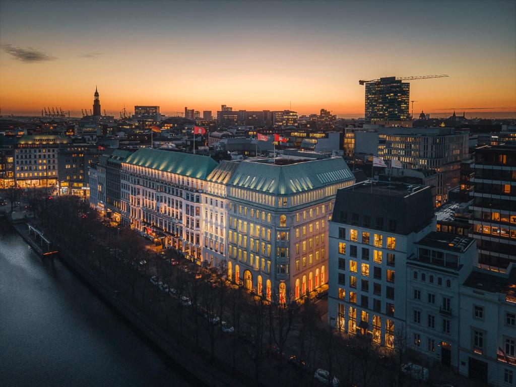 a view of a city with a building at sunset at Fairmont Hotel Vier Jahreszeiten in Hamburg