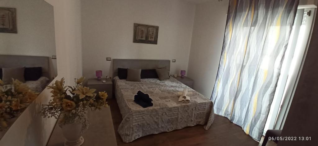 a bedroom with a bed and a table with flowers on it at Mare e relax in Quartucciu