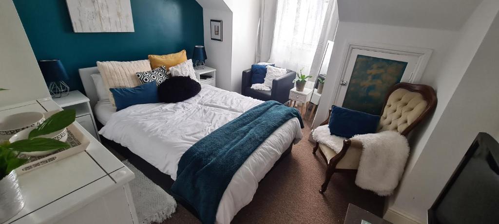 een slaapkamer met een bed met een blauwe muur bij Cosy Caroline's in Plymouth