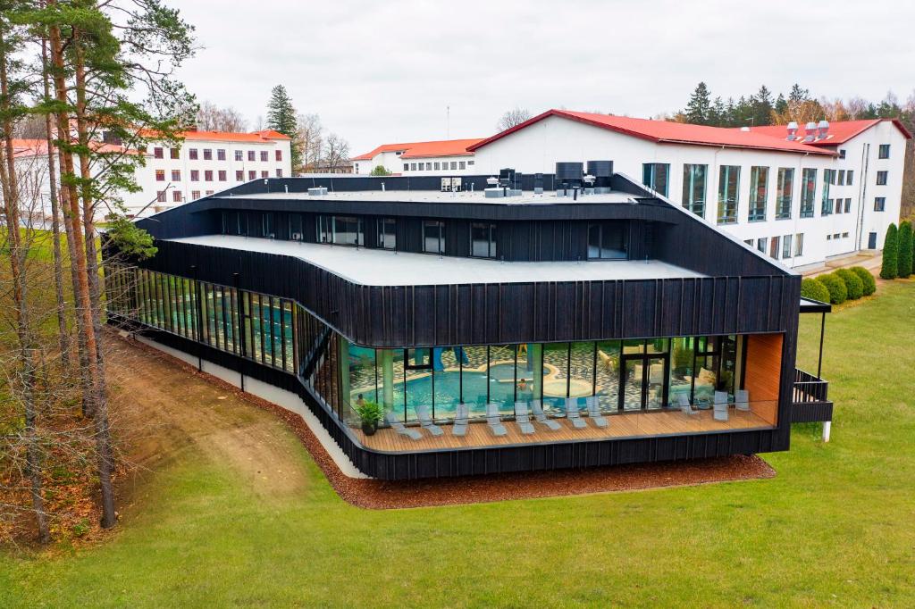 un grand bâtiment noir avec une piscine dans l'établissement Tõrva Veemõnula Spaahotell, à Tõrva