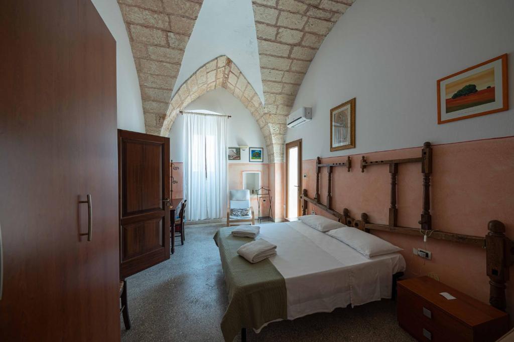 1 dormitorio con 1 cama grande en una habitación en B&B Palazzo la Traja, en Gagliano del Capo