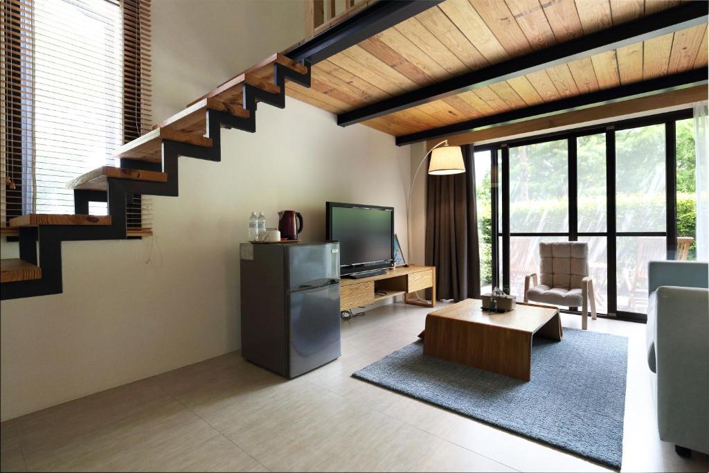 a living room with a staircase and a television at Chuying Sunrise B&amp;B in Ji&#39;an