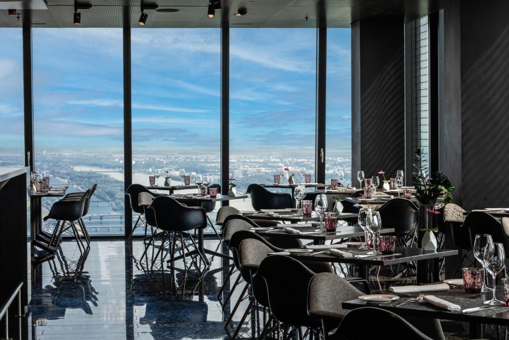 a restaurant with tables and chairs and a view of the city at Melia Vienna in Vienna