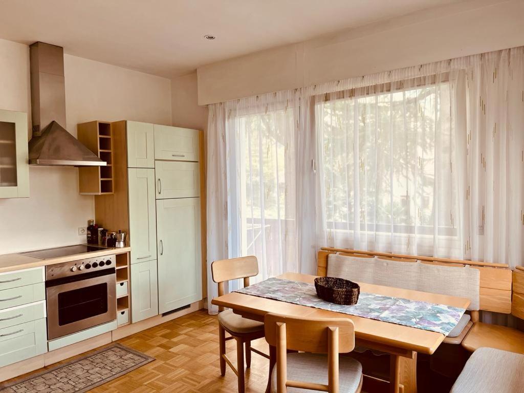 a kitchen with a wooden table and a table and chairs at Naif-Home in Merano