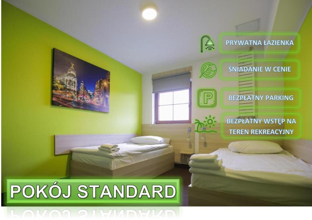Habitación verde con 2 camas y un cartel en la pared en Hotel Karczma u Macieja en Bolków