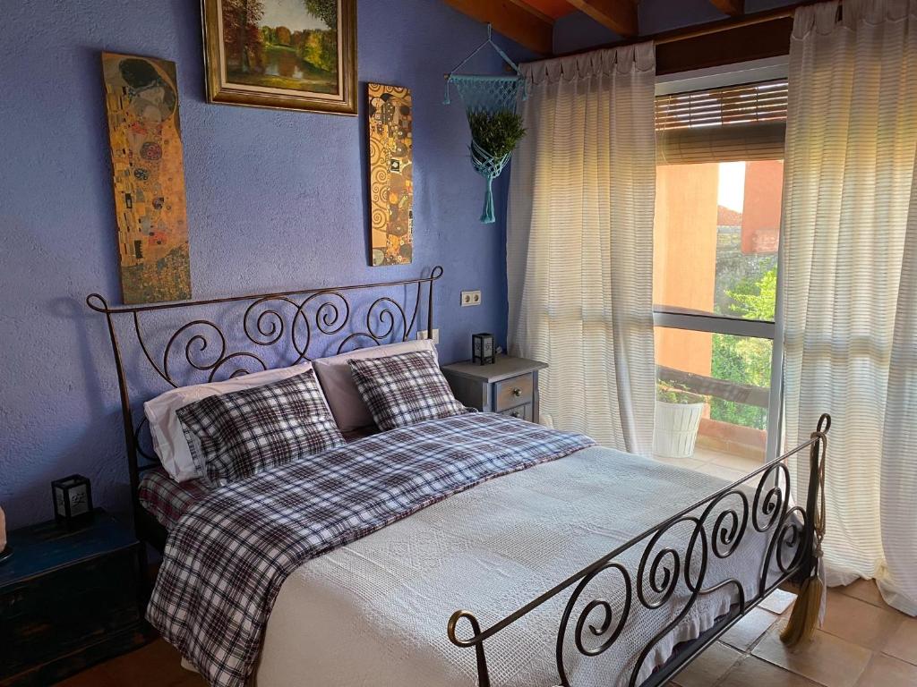 1 cama en un dormitorio azul con ventana en CAN LLUNA Tú casa zen, en Tàrbena