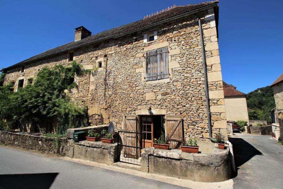 an old stone building with a door on a street at Joli gîte pour 5 personnes : Chez Cherrie in Saint-Julien-de-Lampon