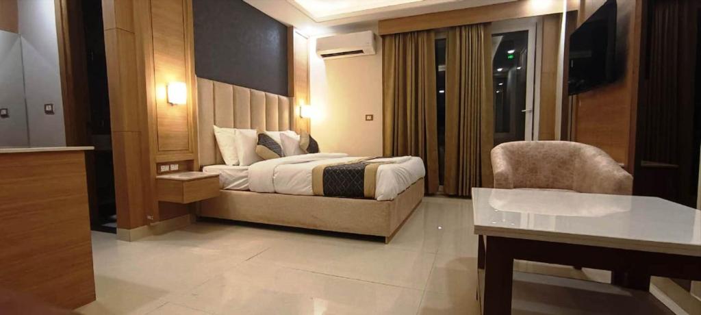 a bedroom with a bed and a chair in a room at Hotel Sakura by Maps in Gurgaon