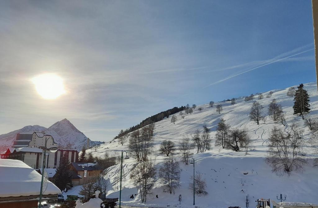 una montaña cubierta de nieve con el sol en el cielo en Appartement de 28 m2, centre station les 2 alpes, en Les Deux Alpes