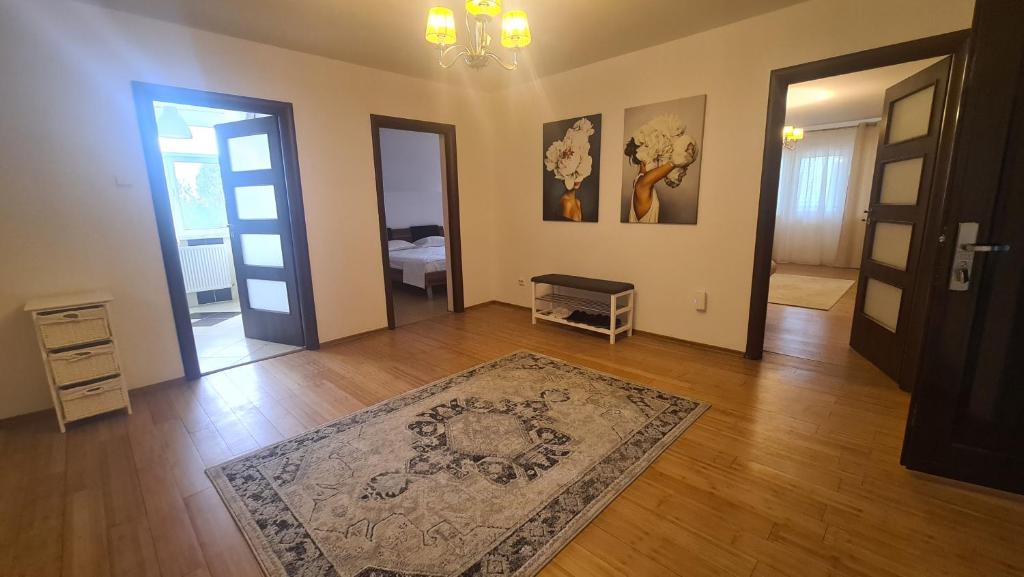 uma sala de estar com um tapete num piso de madeira em Classic Apartament em Buzau