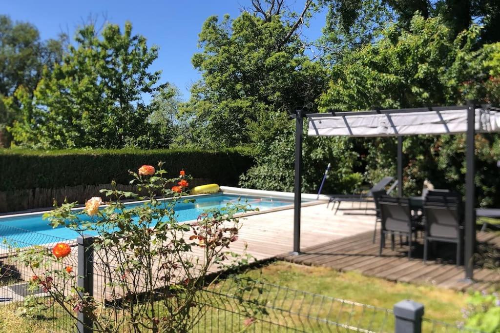 a backyard with a swimming pool and a pergola at Gîte de charme en Dordogne avec Piscine et jardin in Jumilhac-le-Grand
