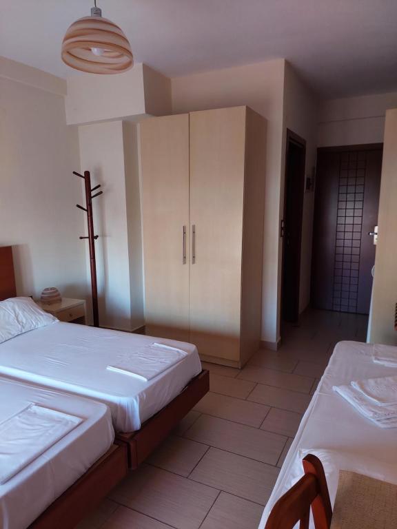 1 dormitorio con 2 camas y armarios blancos en Telethrio, en Loutra Edipsou