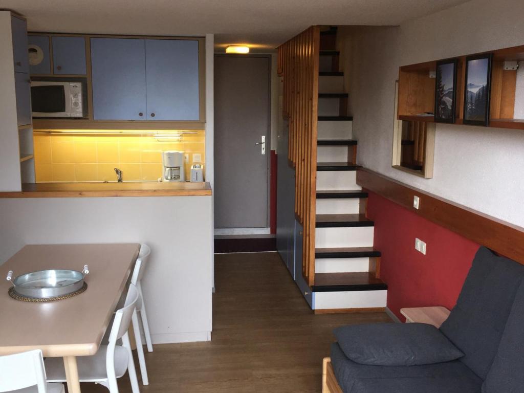 - une petite cuisine et un escalier dans un petit appartement dans l'établissement Duplex confort au pied des pistes avec balcon, parking et WiFi gratuits - Arc 1800 - FR-1-346-380, à Arc 1800