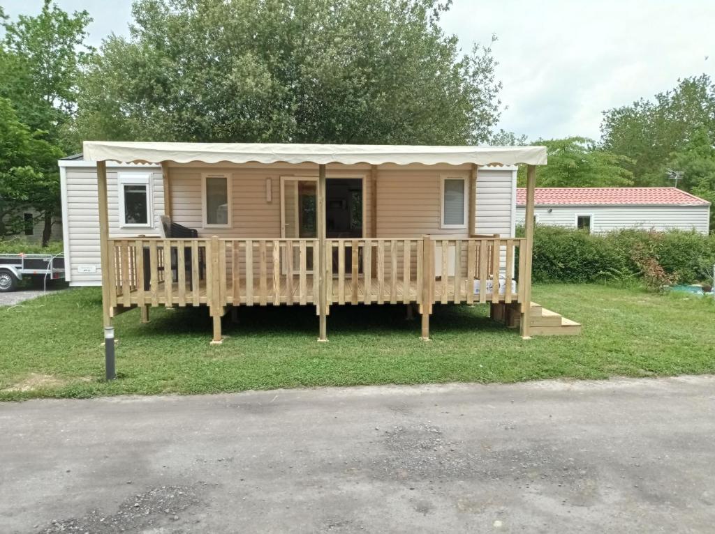 a tiny house with a porch and a deck at MOBIL-HOME NEUF 6 PERSONNES réservation du samedi au samedi en juillet et août in Urt