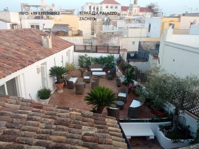 an outdoor patio with potted plants on a building at Palazzo Zacheo in Gallipoli