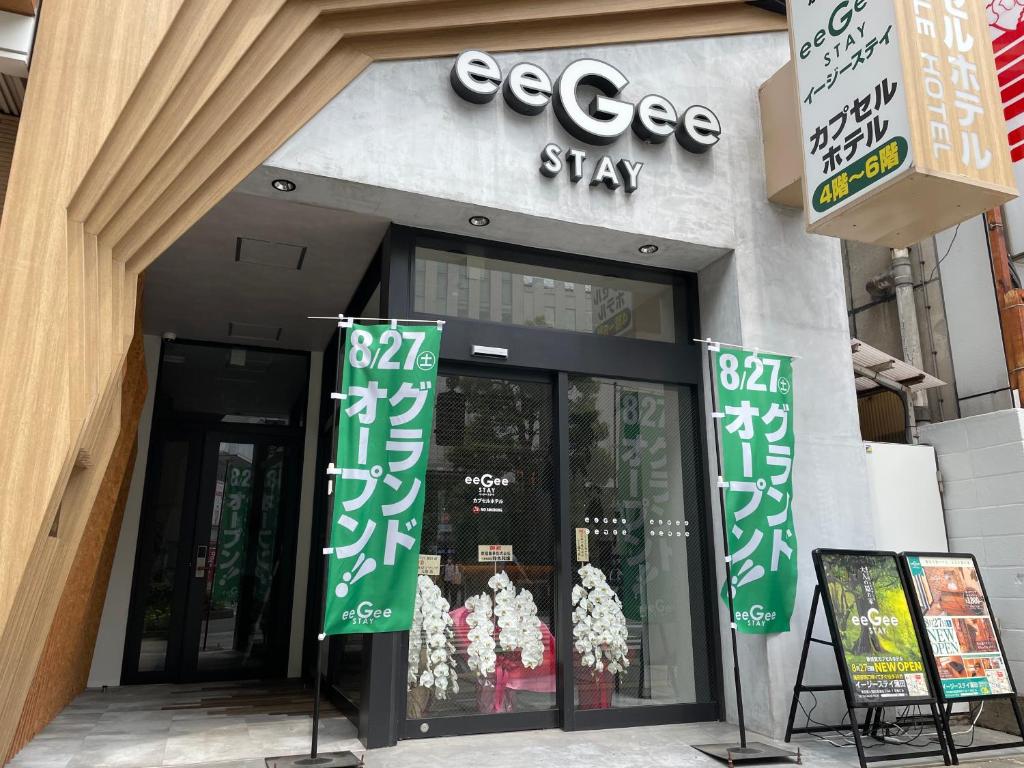 uma loja com sinais verdes em frente em eeGee STAY Kamata em Tóquio