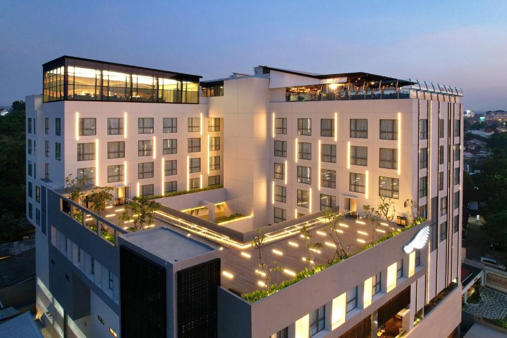a large white building with lights on top of it at Hotel Aruss Semarang in Semarang