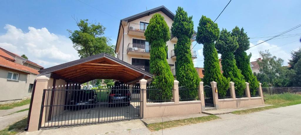 a fence in front of a building with trees at Apart SKY Residence Villa in Boleč