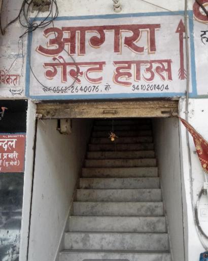 un conjunto de escaleras con una señal encima en Agra Guest House By WB Inn en Agra