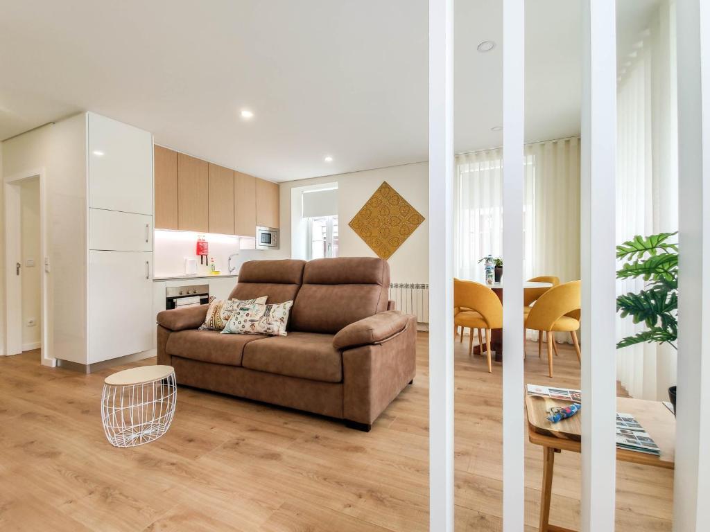 uma sala de estar com um sofá e uma cozinha em Senhora da Agonia - Apartment in Ribeira em Viana do Castelo