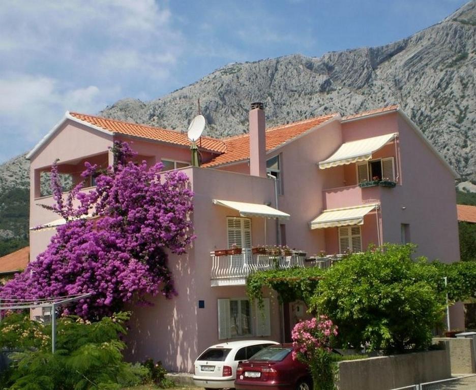 a pink house with a purple flowering tree in front of it at Apartments with a parking space Orebic, Peljesac - 14834 in Orebić